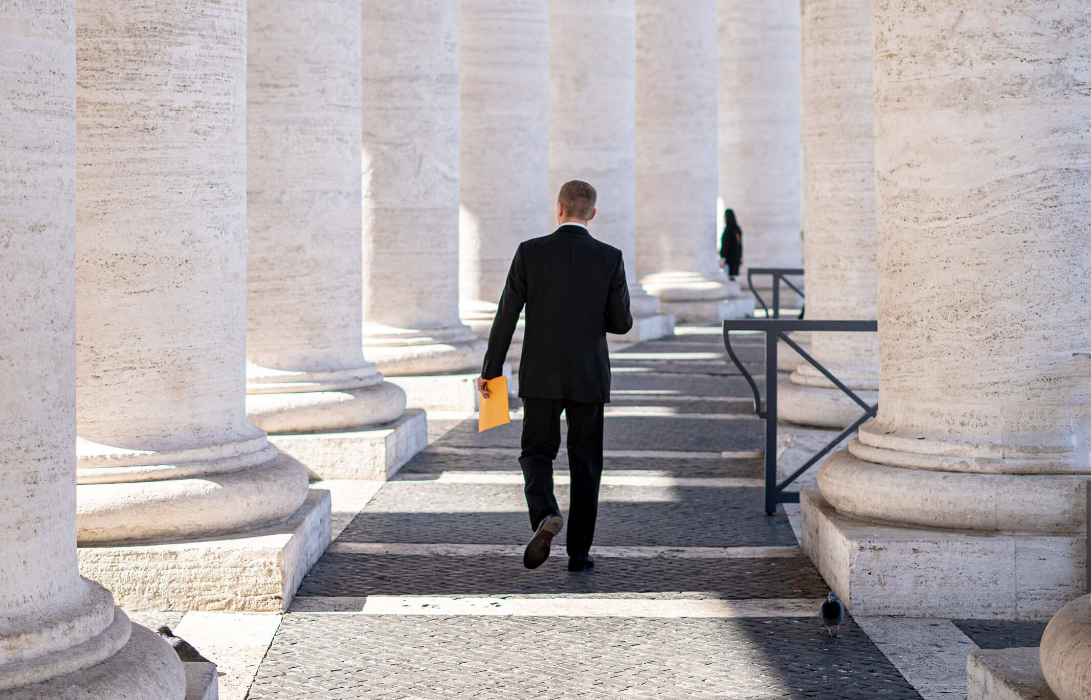 man walking through columns